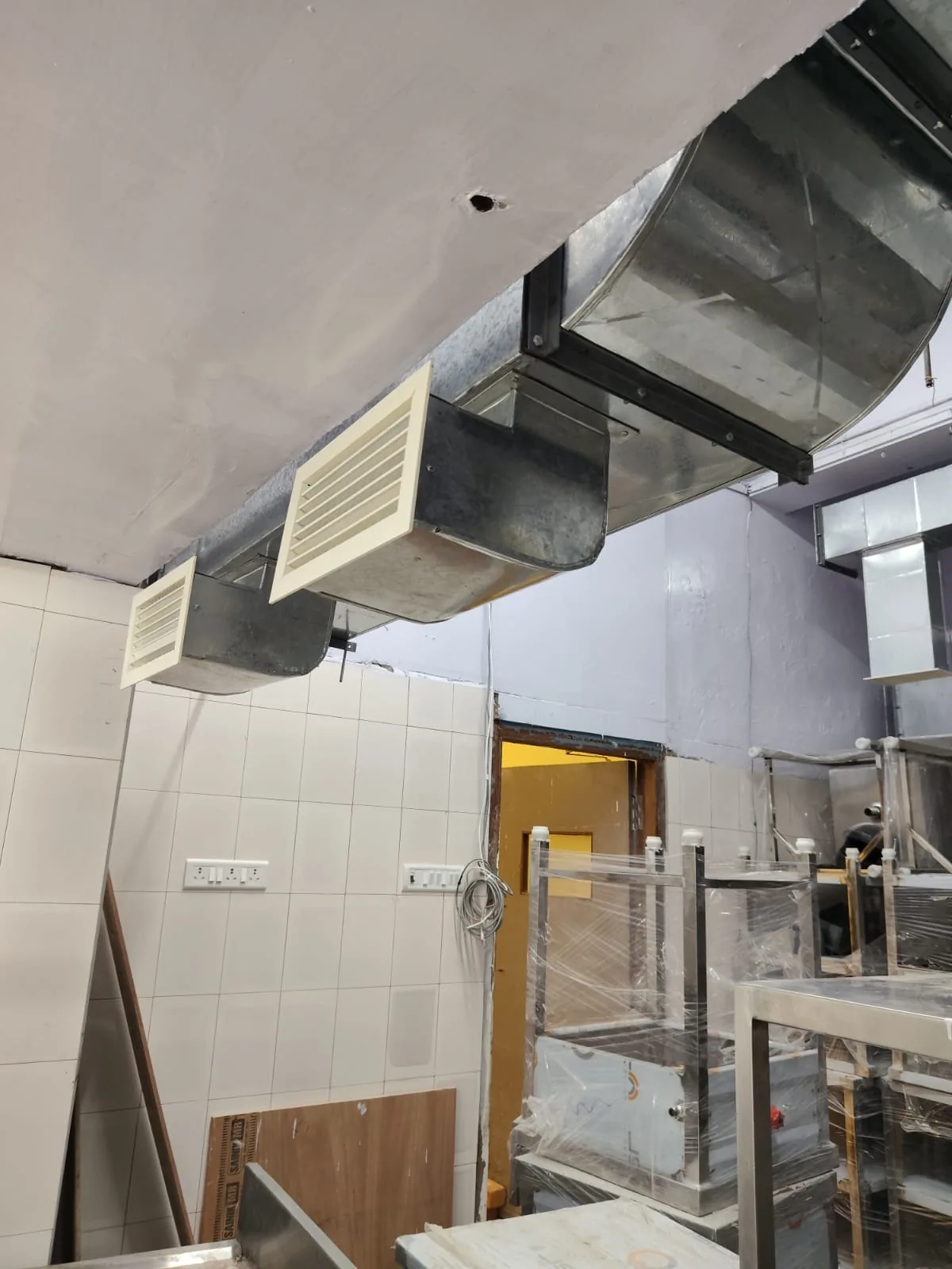 Fresh air duct with grille outlets fitted below a kitchen ceiling