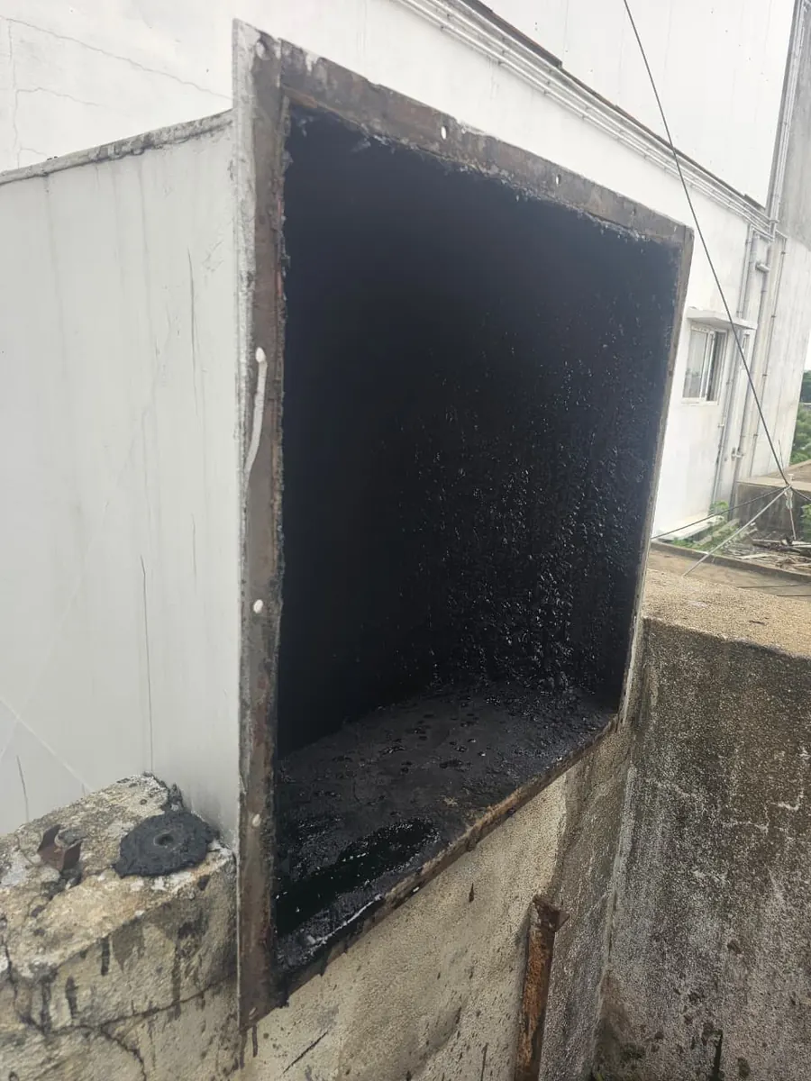 Open duct section showing grease build-up before cleaning