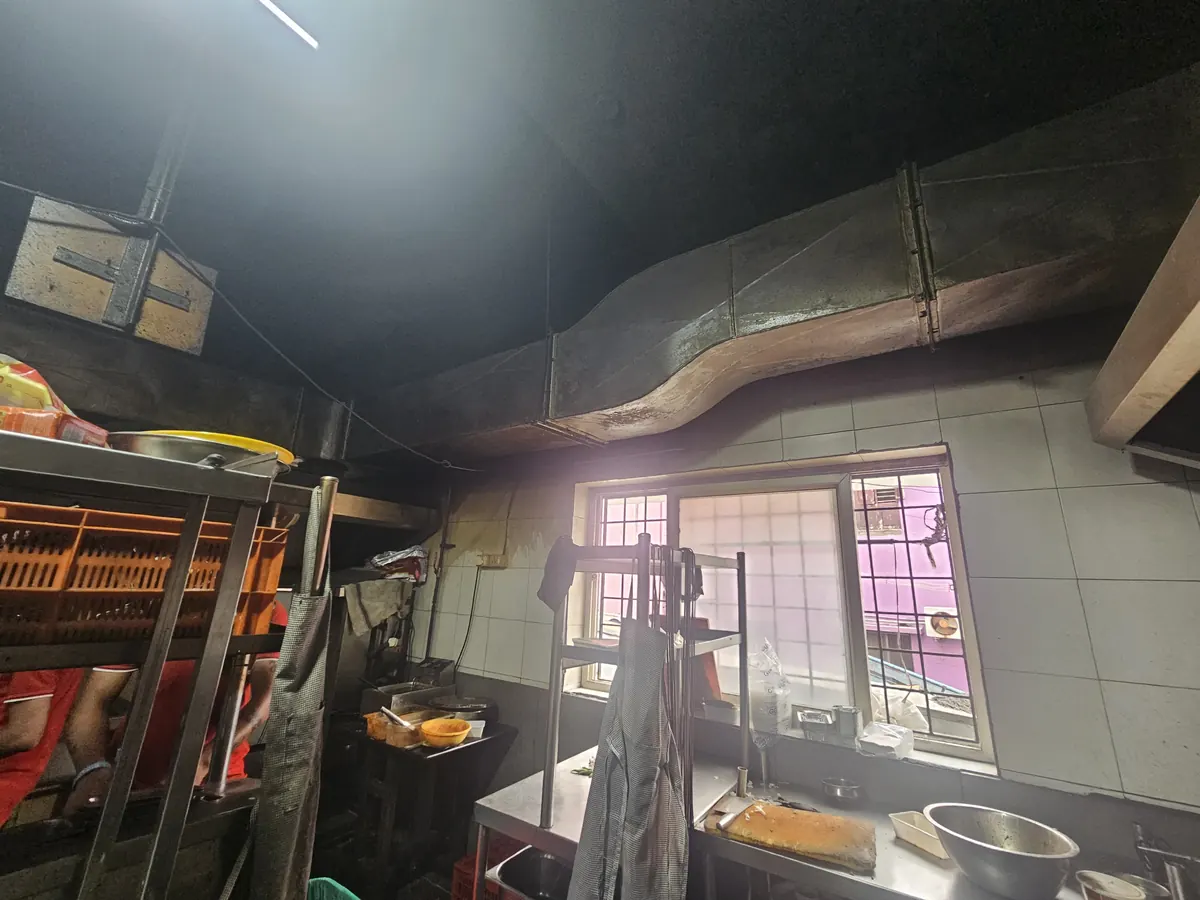 Exhaust ducting routed across the ceiling of a working kitchen