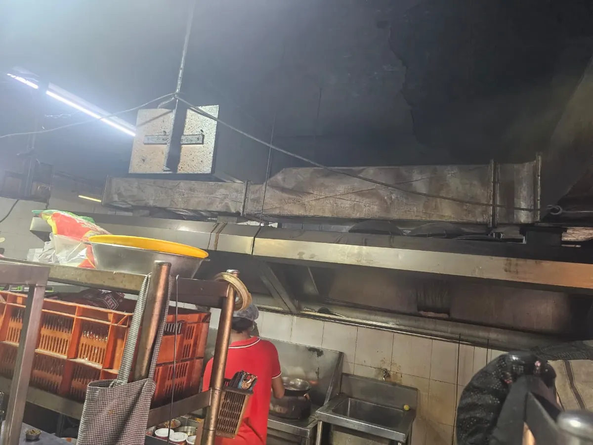 Hood and duct fitted above a busy commercial cooking line