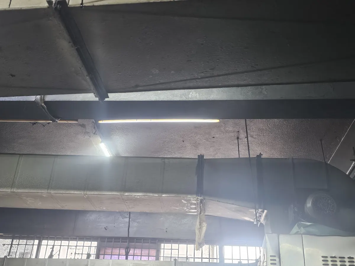 Exhaust duct run carried across the ceiling of a large hall