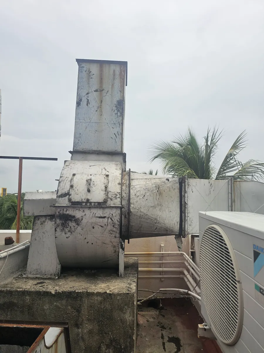 Rooftop blower unit with its discharge stack on a terrace